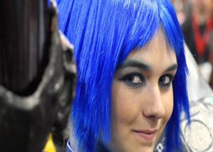 Cosmetology client with bright blue short hair.