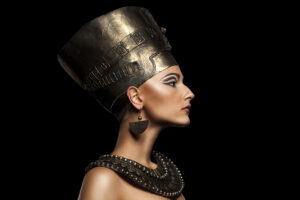 A side profile of women dressed in Egyptian wear with her makeup professionally done.