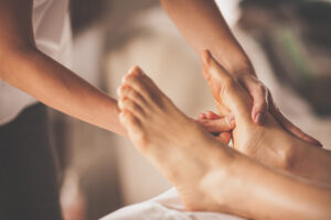 A massage therapist massaging the souls of a client's feet.