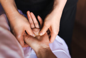 A massage therapist giving a hand massage to a client.