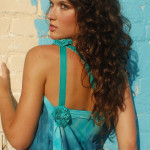 Model showing off a hairstyle, she is facing a wall, looking back over her left shoulder. 