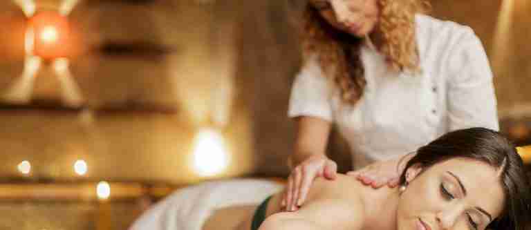 A massage therapist giving a client a back massage.