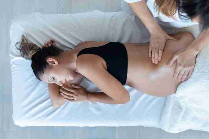 A massage therapist giving a pregnant woman a pregnancy safe massage.