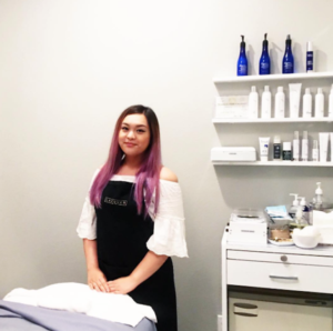 An esthetician student standing in a service room ready for an appointment.