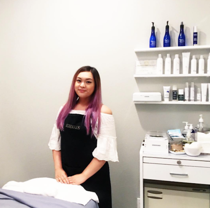 An esthetician student standing in a service room ready for an appointment.