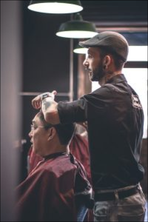 Barber student cutting hair in the salon at Avenue Five Institute, focused on honing their skills in a hands-on environment.