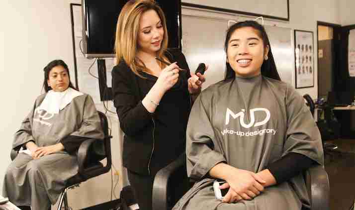 a young woman getting her makeup done