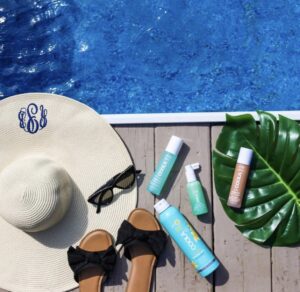 An ariel view of a woman's hat, and pool supplies by the side of the pool.