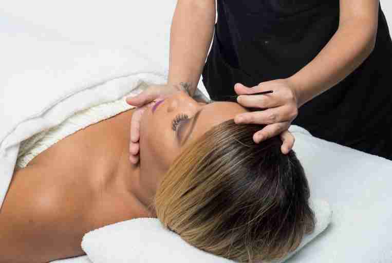 Esthetician carefully applying eyelash extensions to a client in a professional salon setting.