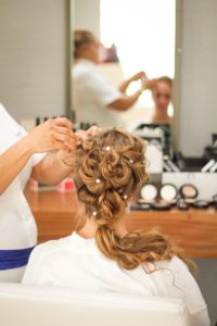 cosmetology vs makeup artist - cosmetology student works on fancy updo