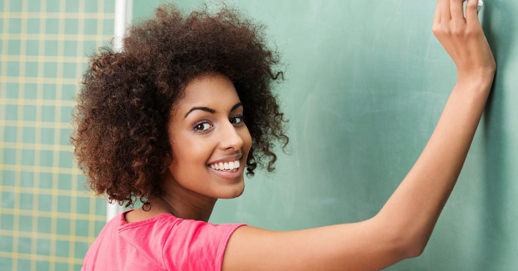 a woman writing on a chalkboard