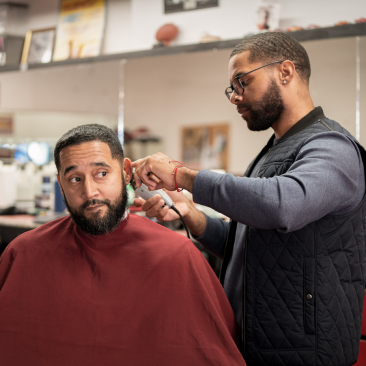 a man cutting another man's hair