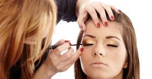 a woman getting her eye makeup done