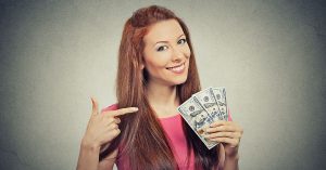 a woman smiling while holding money
