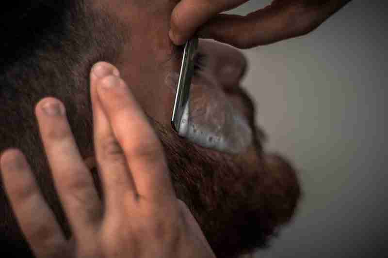a man getting his beard trimmed