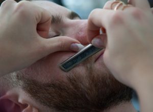 a man getting his beard trimmed