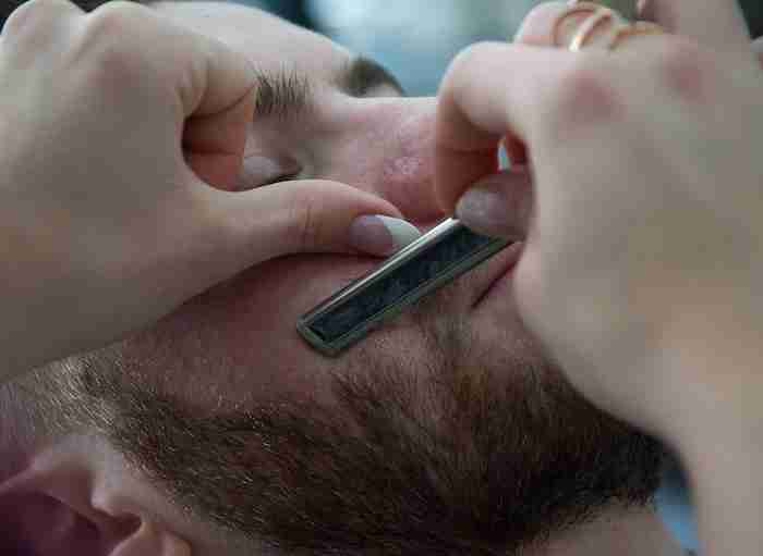 a man getting his beard trimmed