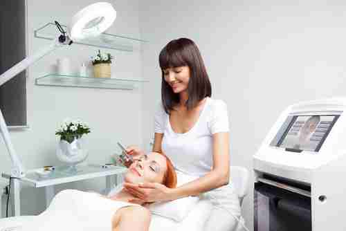 Beauty technician applying products on client during a facial