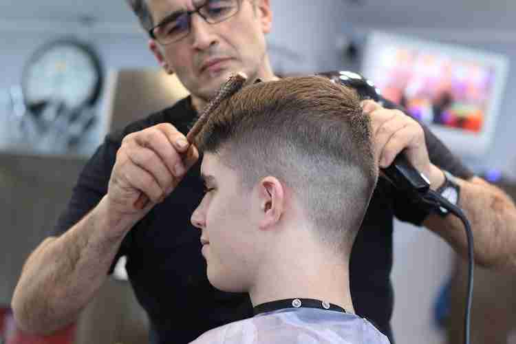 a teenage boy getting his hair cut